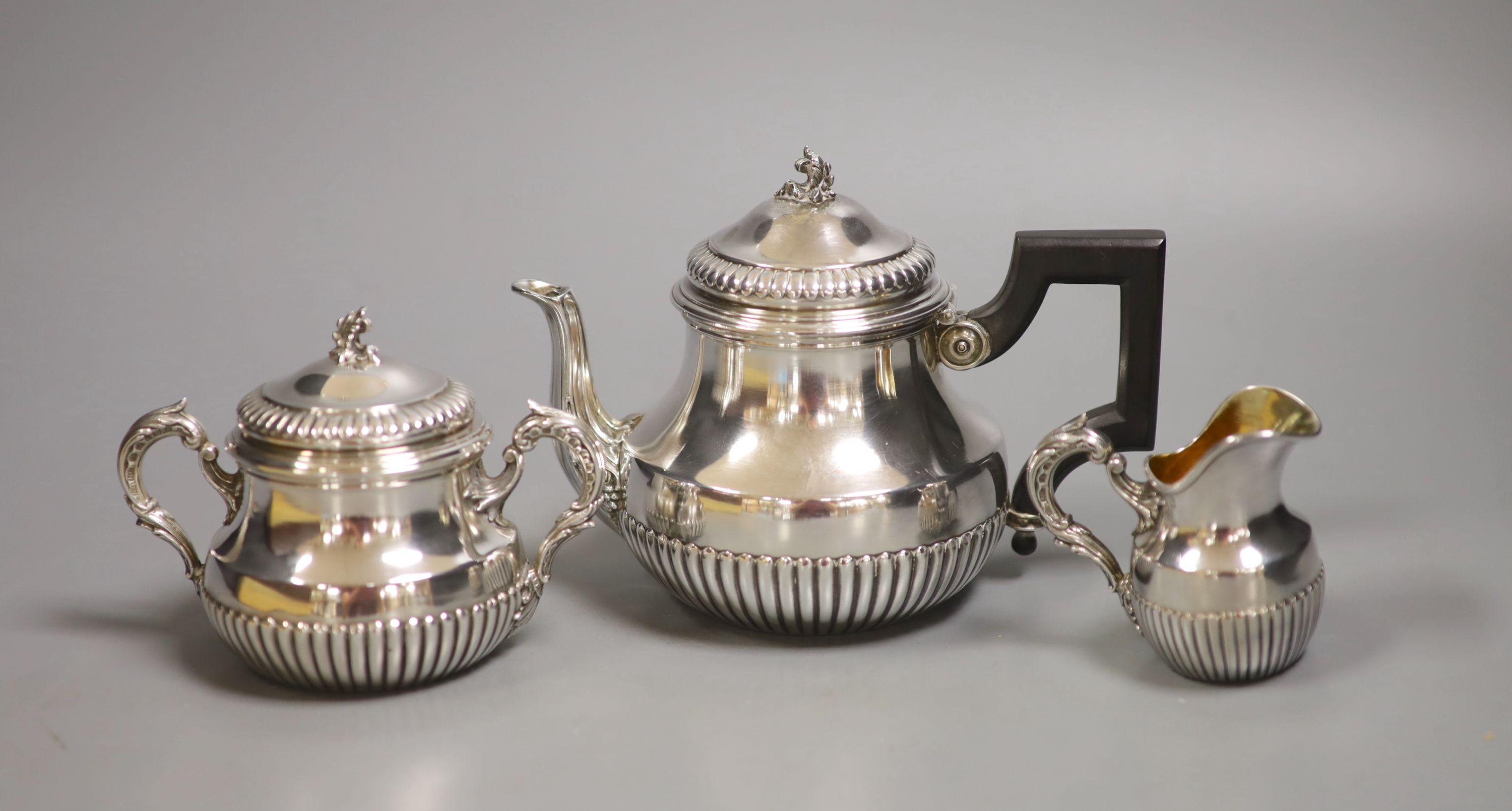 A cased late 19th/early 20th century French demi fluted white metal three piece tea set, by Edmond Tetard